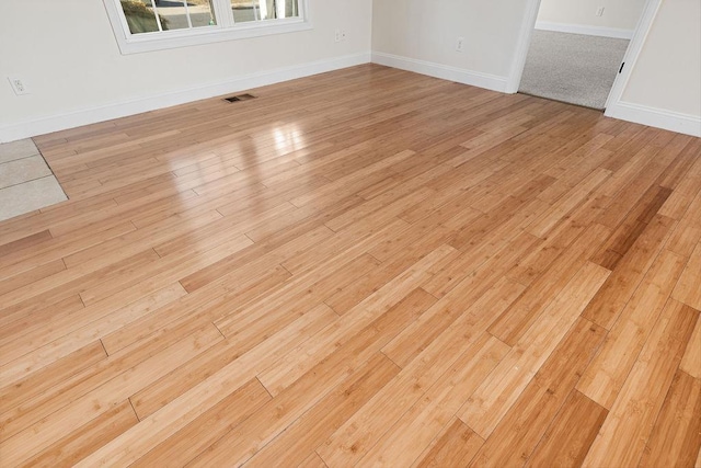 interior details with wood finished floors, visible vents, and baseboards