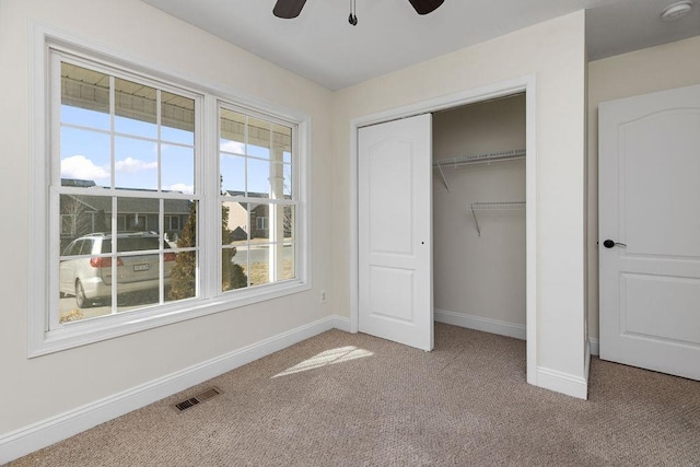 unfurnished bedroom featuring a closet, visible vents, light carpet, and baseboards