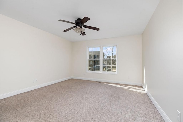 empty room featuring a ceiling fan, carpet flooring, and baseboards