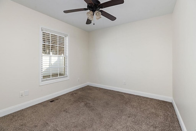 unfurnished room with ceiling fan, carpet floors, visible vents, and baseboards