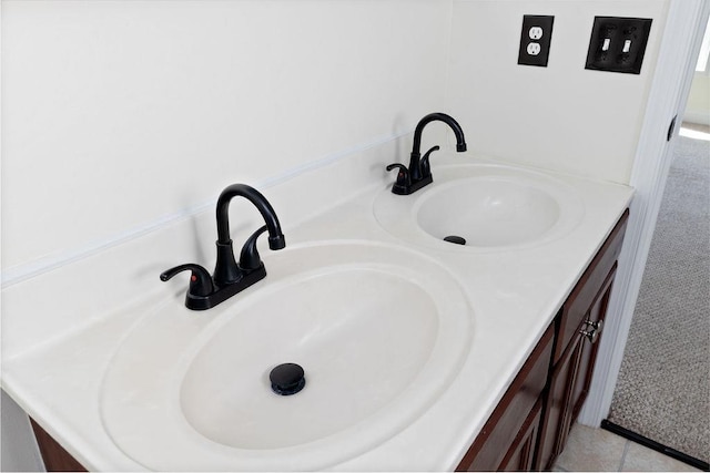 bathroom featuring double vanity, a sink, and tile patterned floors