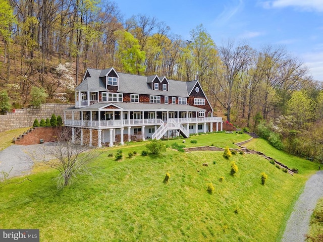 back of property with a deck and a lawn