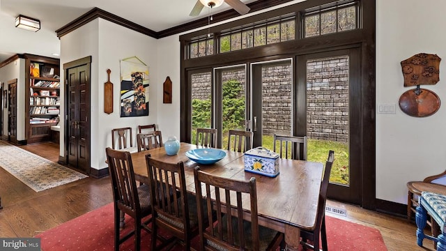 dining area with crown molding, ceiling fan, and dark hardwood / wood-style flooring