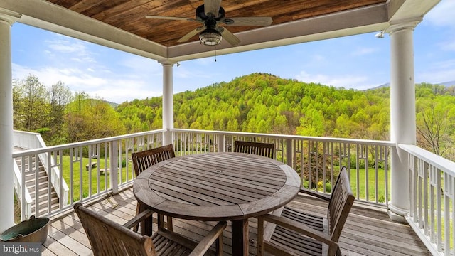 wooden terrace featuring a yard and ceiling fan