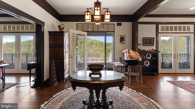 interior space with beam ceiling, a notable chandelier, dark hardwood / wood-style flooring, and french doors