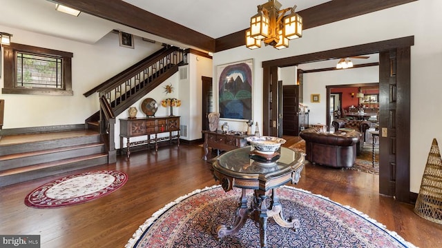 entryway featuring dark wood-type flooring, a notable chandelier, and beam ceiling