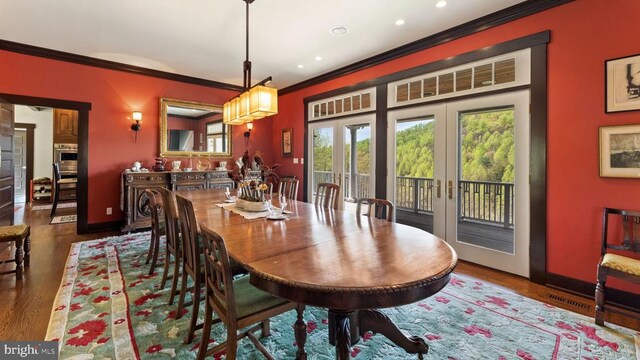 dining area featuring dark hardwood / wood-style floors, ornamental molding, and french doors