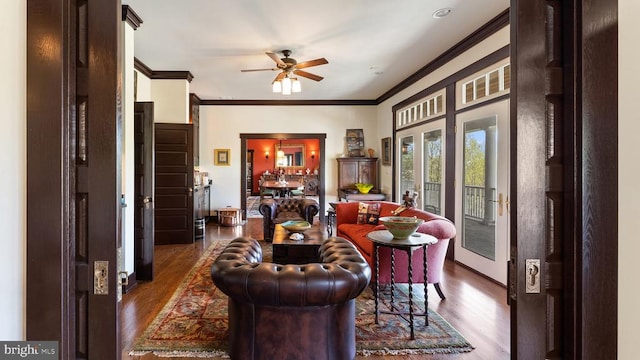 living room featuring crown molding, dark wood-type flooring, and ceiling fan