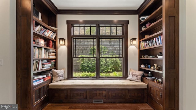 sitting room featuring crown molding and built in features