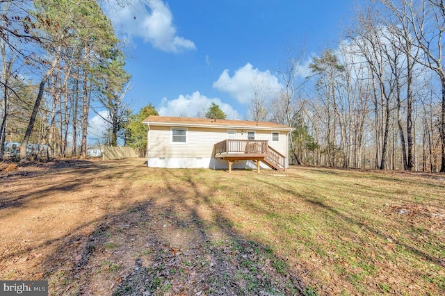 rear view of property with a wooden deck and a lawn