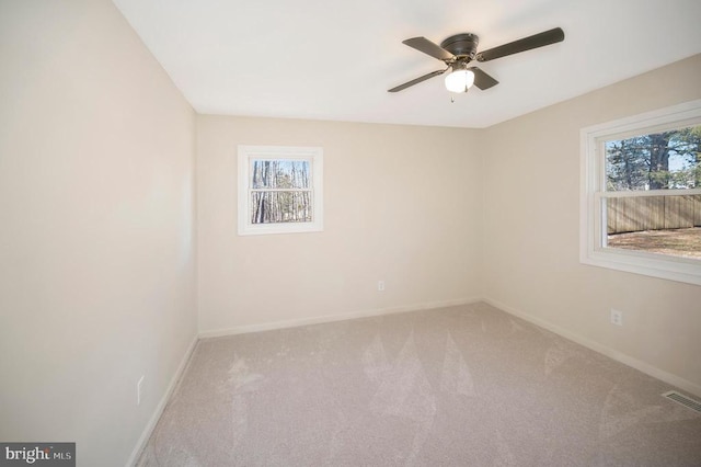 spare room with ceiling fan, carpet floors, and a wealth of natural light