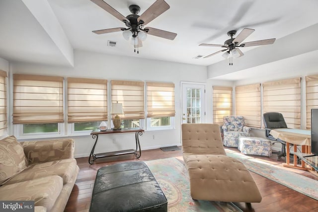 living room featuring dark wood-type flooring and ceiling fan