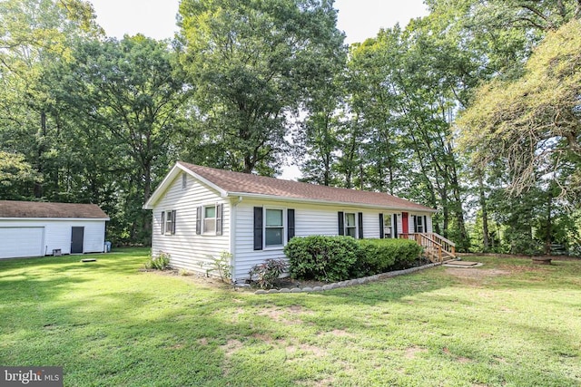 ranch-style home featuring a garage, an outbuilding, and a front yard