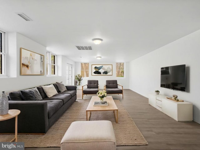 living area with visible vents and wood finished floors