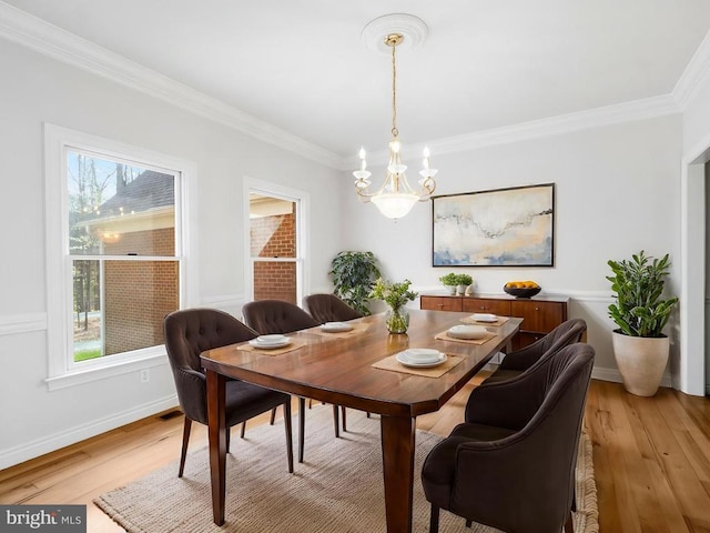 dining area with a chandelier, plenty of natural light, light wood finished floors, and ornamental molding