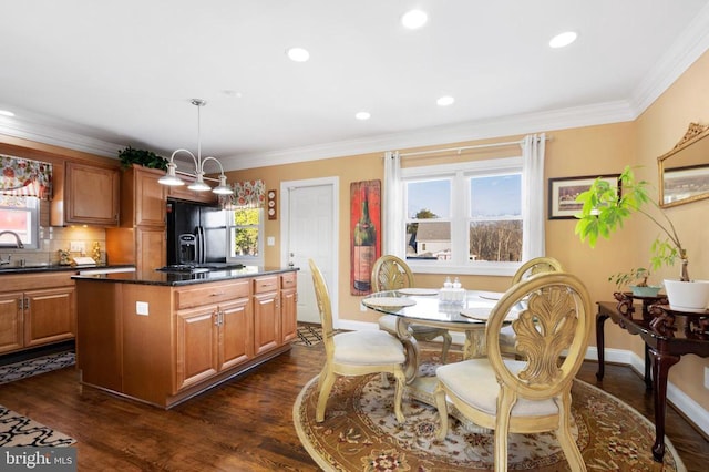 kitchen featuring black fridge with ice dispenser, decorative light fixtures, a center island, dark stone countertops, and dark hardwood / wood-style floors