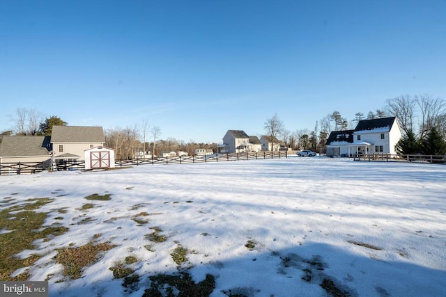 yard layered in snow featuring a shed