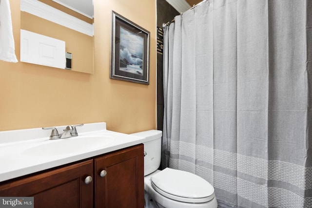 bathroom with vanity, crown molding, and toilet