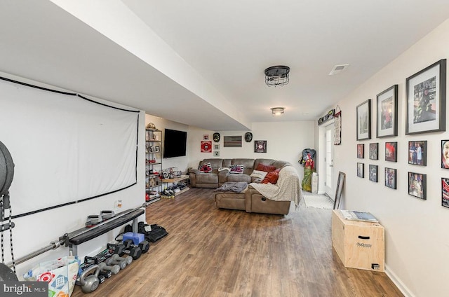 living area with visible vents, baseboards, and wood finished floors