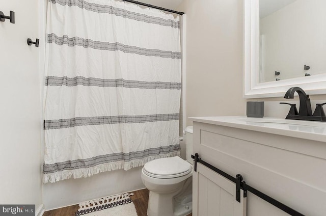 full bath with vanity, shower / bath combination with curtain, wood finished floors, and toilet