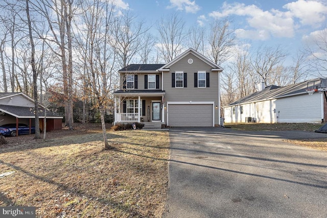 view of front facade featuring a garage, covered porch, and aphalt driveway