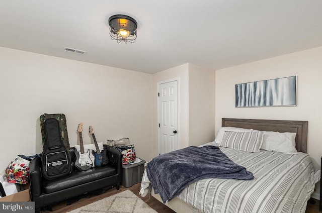 bedroom featuring visible vents and wood finished floors