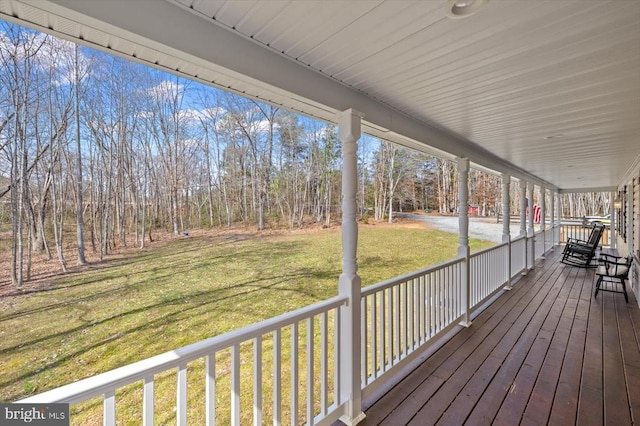 deck featuring a lawn and covered porch