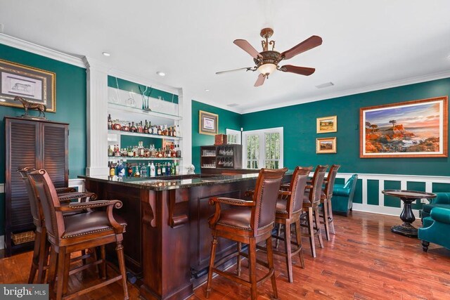 bar featuring crown molding, wood-type flooring, and ceiling fan