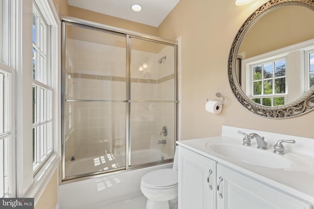 full bath with vanity, combined bath / shower with glass door, and toilet