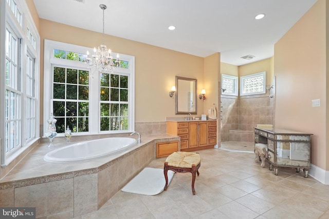 bathroom with an inviting chandelier, a walk in shower, tile patterned flooring, and a garden tub