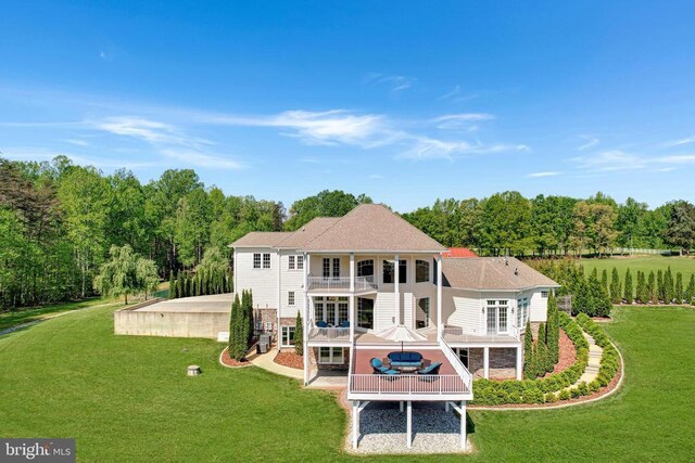 back of property featuring a balcony, a yard, and a patio