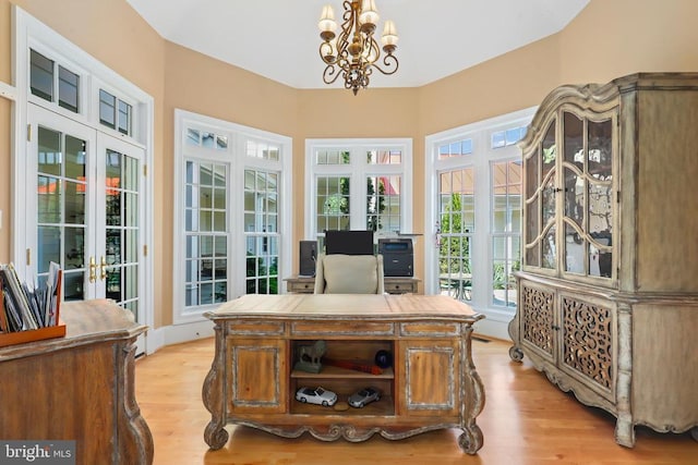 office space with an inviting chandelier, french doors, and light wood-style floors