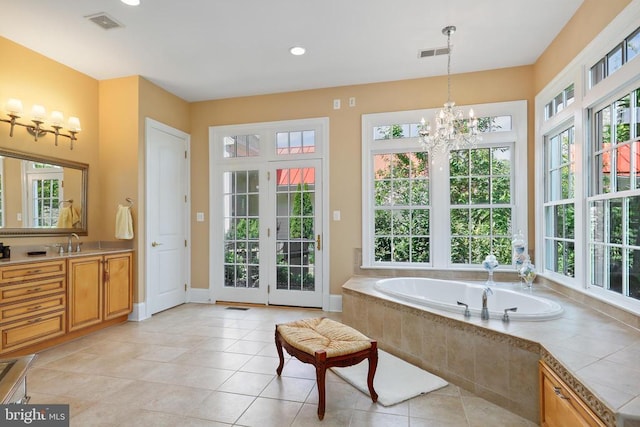 bathroom featuring a healthy amount of sunlight, a notable chandelier, and visible vents