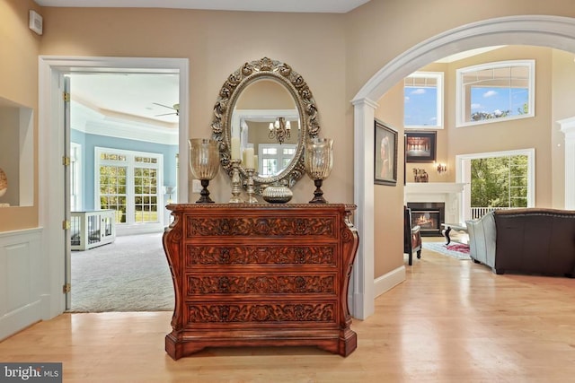 hallway featuring plenty of natural light, arched walkways, and wood finished floors