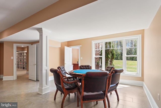 dining room with ornate columns, baseboards, and light tile patterned floors