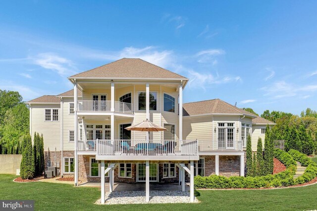 back of house with central AC, a patio area, a balcony, a lawn, and a deck