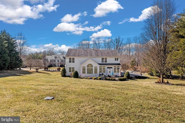 rear view of property with a lawn