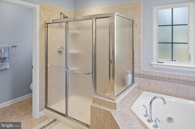 full bath featuring a stall shower, a jetted tub, baseboards, and tile patterned floors