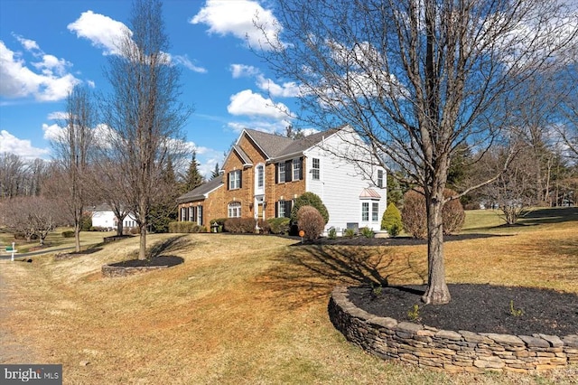 view of side of home with brick siding and a lawn