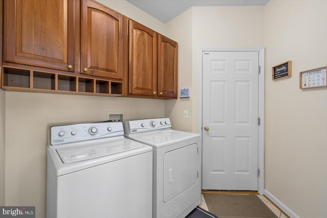 washroom featuring cabinet space, independent washer and dryer, and baseboards