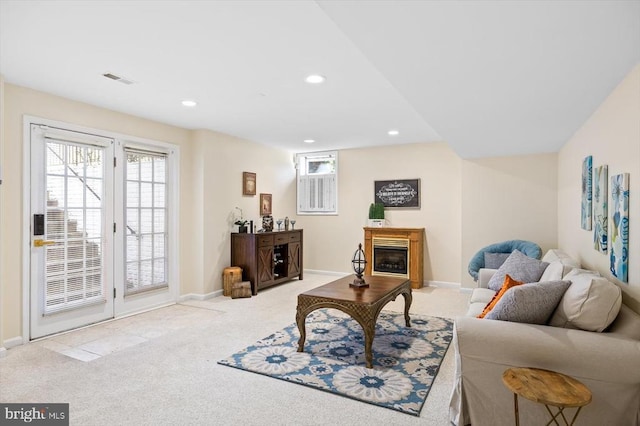 living area with recessed lighting, baseboards, carpet flooring, and a glass covered fireplace