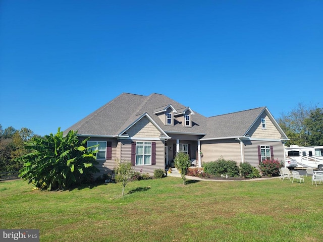 view of front of home with a shingled roof and a front lawn