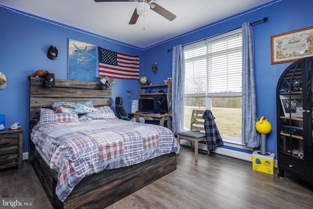 bedroom with ceiling fan, baseboards, and wood finished floors