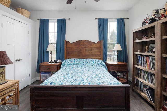 bedroom with multiple windows, ceiling fan, baseboards, and wood finished floors