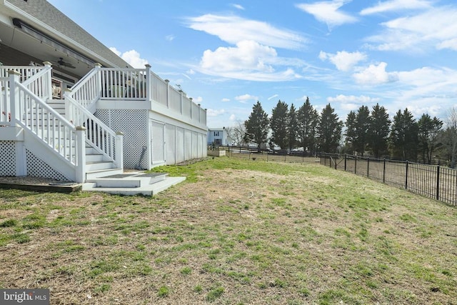 view of yard featuring ceiling fan, stairs, fence, and a wooden deck