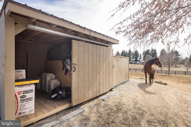 view of outdoor structure featuring fence and an outbuilding