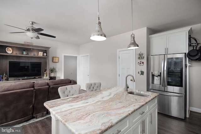 kitchen with dark wood finished floors, stainless steel refrigerator with ice dispenser, a sink, and white cabinetry