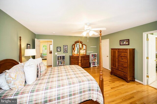bedroom with baseboards, ceiling fan, and light wood-style flooring