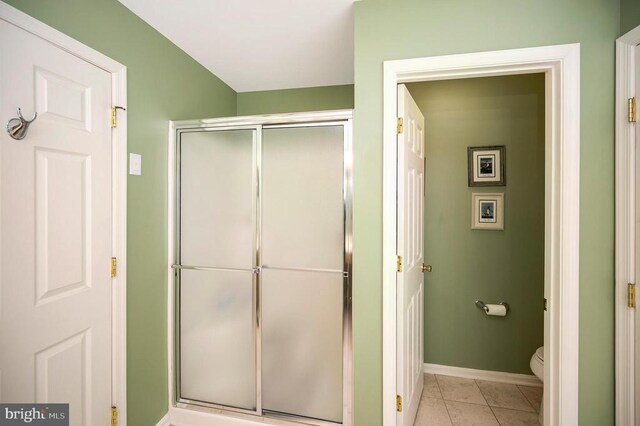 full bathroom with toilet, baseboards, a shower stall, and tile patterned floors