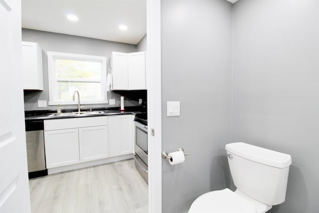 kitchen with white cabinetry, sink, stainless steel appliances, and light wood-type flooring